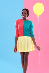 Image showing Black woman, fashion and portrait, balloon and smile or happiness with color block background. Stylish, trendy and vibrant for female model person, fun and unique retro clothing for hipster in studio