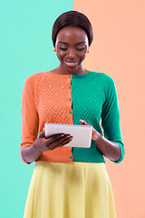Image showing Black woman, fashion and tablet in studio, smile or happiness with color block background. Stylish, trendy or vibrant female model person, vlogging or blogging in unique clothing for digital hipster