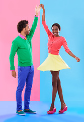 Image showing Happy, dance and couple in studio with fashion and holding hands, spinning and creative portrait. African, woman and man together with colorful retro style, unique clothes or moving with support