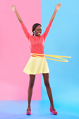 Image showing Woman, smile and hand up for victory, dance and hoop for success on color block background. Winner, female person and spinning of plastic toy to celebrate, achievement or good news in studio