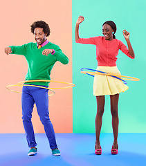 Image showing Couple of friends, laugh and play for dance, hoop and competition on color block background. Excited, man and woman for bonding, spinning and plastic toy for funky, quirky and game in studio