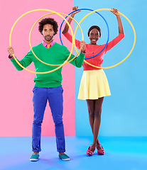 Image showing People, smile or hoop for fashion, casual or spring outfit for playful aesthetic on color block background. Portrait, man or woman for plastic toy in funky, colorful or stylish clothing in studio