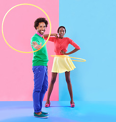 Image showing Couple, fashion and trendy in studio with colour clothes, smile and playful expression on black people together. Artistic, aesthetic in retro style for unique designer, summer fun and hula hoop