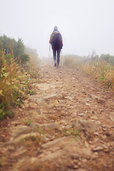 Image showing Person, hiking and back for trekking in mountain, adventure and support with sticks for nature trail. Athlete, backpack and sport gear for safety in cold environment, healthy and walking for fitness