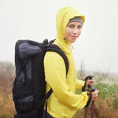 Image showing Portrait, female hiker and fog on mountain trail, exercise and cardio for fitness in nature. Smile, walking stick and gear for training and morning overcast weather, workout and happy or rest on path