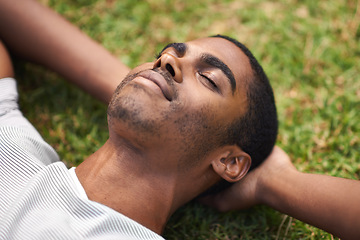 Image showing Face, relax and black man on grass in garden of summer home for peace, wellness or mindfulness. Nature, field and sunshine with happy young person lying on green ground from above for break or rest