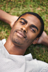 Image showing Black man, relax and lying on grass while resting, sleeping and enjoy summer or nature outdoor. Male person, smile and sunshine after holiday, calm guy and happiness in garden or field or outside