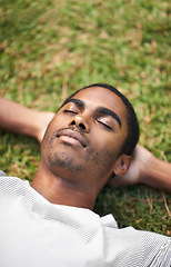 Image showing Face, sleep and black man on grass in garden of summer home for peace, wellness or mindfulness. Nature, relax and filed with calm young person lying on green ground from above for break or rest