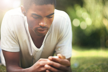 Image showing Music, summer and earphones with black man on grass in garden, park or field to relax outdoor. Face, nature and wellness with young person streaming or listening to radio sound or audio in fresh air