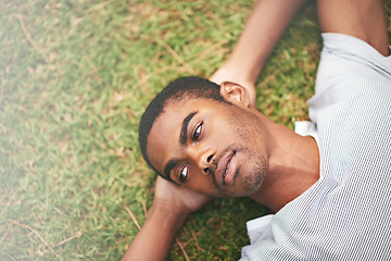 Image showing Face, relax and thinking with black man in garden of summer home for peace, wellness or mindfulness. Nature, field and grass with thoughtful young person lying on ground from above for break or rest