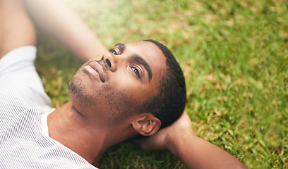 Image showing Face, thinking and black man on grass in garden of summer home for peace, wellness or mindfulness. Nature, field and relax with thoughtful young person lying on ground from above for break or rest