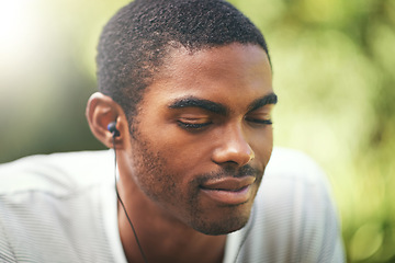 Image showing Face, music and relax with black man in nature or park outdoor for summer, peace and quiet. Garden, radio and wellness with calm young person streaming audio or sound on earphones in backyard