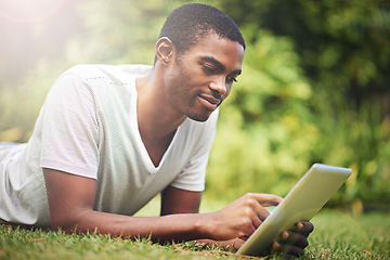 Image showing Relax, happy and tablet with black man on grass of garden for research or information in summer. Technology, internet and young person reading online ebook on green field outdoor in backyard