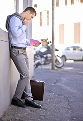 Image showing Business, job loss and man on street, fired and reading letter of unemployment on city sidewalk. Anxiety, mental health and sad businessman on road with termination notice, briefcase and pink slip