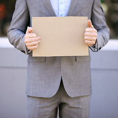 Image showing Blank, cardboard and unemployment person with suit, poster and mockup for job hunting outdoor. Professional, hands and businessman sign to seek or search for work on street in city of Cape Town