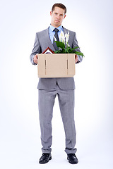 Image showing Businessman, suit and box for resignation, fired or transfer at company for liquidation on white backdrop. Employee, worker and sad person for organization loss, fraud and turnover with memorabilia