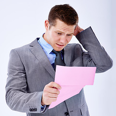 Image showing Stressed, businessman and termination letter for work professional, formal and reading in white background. Male person, salesman and disappointed with job paper, fired and unemployment in studio