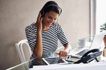 Image showing Woman, home and office with technology, headset and listening to podcast while working on tablet for freelance job. Female person, internet or online with headphone for communication or consulting.