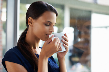 Image showing Woman, relax and drinking coffee in home for peace, calm and energy at breakfast in the morning. Matcha, tea cup and young person with espresso, latte or hot healthy beverage for wellness by window