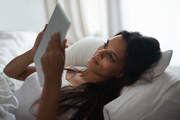 Image showing Tablet, bed and social media with woman in morning to relax, wake up on weekend or reading ebook. Technology, app and internet with young person in bedroom of home for online literature or story