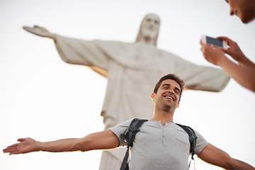 Image showing Man, photo and travel by christ the redeemer, crucify and happy in christian culture on vacation. Jesus sculpture, rio or guy for social media update in mobile picture, peace or tourism in brazil