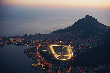 Image showing Mountain, city and lights at night with ocean or highway in urban landscape of Cape Town. Cityscape, drone or aerial view of hill on holiday or travel on vacation with sunset on sea or horizon