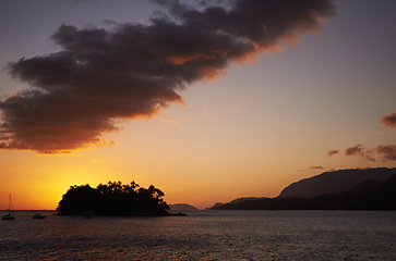 Image showing Tropical, island and ocean with sunset on horizon, travel and relax morning in nature in summer. Holiday destination, calm or boats on sea for vacation, night or view of mountain in beach landscape