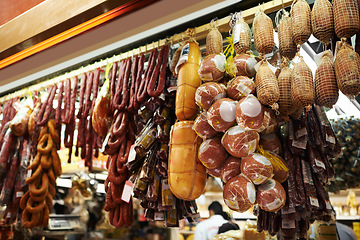 Image showing Hooks, butcher and dry meat in shop for traditional food, groceries or products in Germany. Supermarket, deli and fermented or smoked sausages hanging in row for production in grocery store.