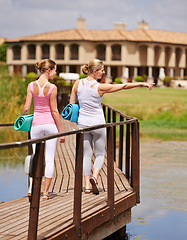 Image showing Fitness, friends and yoga women walking on a bridge with conversation, hand pointing or park view. Wellness, fresh air or back of people on outdoor crossing for balance, chat or morning class commute