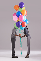 Image showing Couple, party and celebration with balloons for event, birthday or romance on a gray studio background. Man and woman holding colorful blowups of helium for art, date or anniversary on mockup space