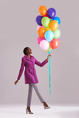 Image showing Balloon, fashion and happy black woman in studio for birthday, celebration and present. Style, excited and isolated person smile with inflatables for party, gift and surprise on gray background