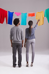 Image showing Laundry, choice and clothing of couple with back view in studio for hygiene, housework, washing in white background. Domestic, black man and woman for household task, clean or fresh fabric on line