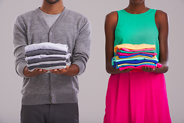 Image showing Hands, couple and clothes for laundry, cleaning and hygiene in studio isolated on a gray background. Man, woman and people with fabric for housework, housekeeping or pile of linen for chores together