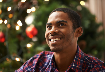 Image showing Man, thinking and happy in home on christmas for celebration, holiday and festive spirit in living room. African person, thoughtful and smile on xmas with relax, confidence and vacation in apartment