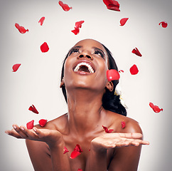 Image showing Flower, throw and black woman in studio for makeup, beauty or wellness on grey background. Floral confetti, smile and African model with soft cosmetics, shine or organic, fun and transformation