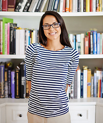 Image showing Woman, portrait and happy by bookshelf in house with books for reading, learning and knowledge in living room. Person, face and confidence by home library with magazine, journal and study collection