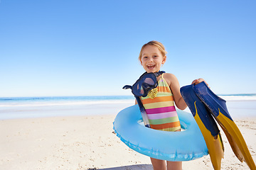 Image showing Beach, child and vacation for swimming in summer with portrait in tranquil environment. Girl, smile and excited person on sand with costume, inflatable and goggles in sun for safety and caution