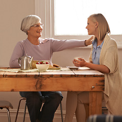 Image showing House, senior and comfort to daughter, visit and elderly mom in dining table with food for breakfast, coffee and snacks with mother. Female person, smile and happiness with parent in family home
