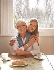 Image showing Family home, retirement and daughter hug mom for breakfast in dining table, coffee and snacks. Female person, smile and happiness with mother in house, elderly and visit from girl, tea and biscuits