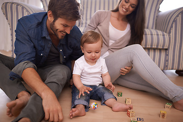 Image showing Parents, toddler and building blocks on floor, love and growth or development toys for learning in living room. Happy family, kid or interactive game for child or bonding together with care in home