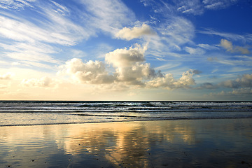 Image showing Sunset, beach and clouds on landscape in nature, evening sun and calm ocean with blue sky. Waves, summer skyline and peaceful environment with island sand, zen location and vacation horizon in Miami