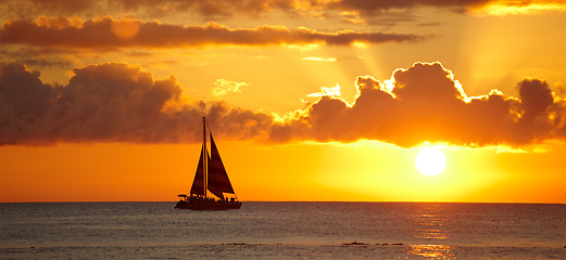 Image showing Boat, beach and sunset with clouds, water and ocean with Waikiki, Honolulu and Hawaii. Dusk, seaside and nature with environment or travelling with vacation and adventure with journey, summer or ship