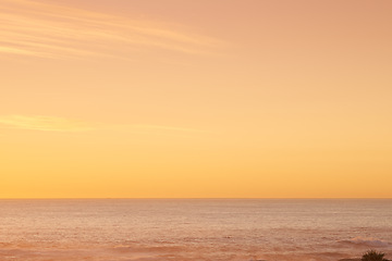 Image showing Beach, sunset and clouds, view and aerial for aesthetic and travel environment and sea. Orange sky, ocean and landscape in summer, trip and vacation for nature and calm sunlight in Singapore holiday