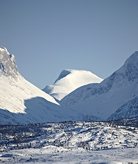 Image showing Mountain, blue sky and snow in winter with landscape of nature, environment and cold weather outdoor. Icy ground, natural background with travel or tourism, ice with frozen location or destination