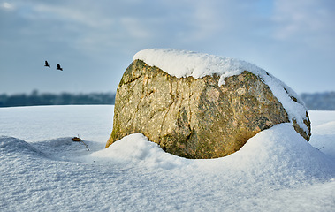 Image showing Rock, nature and snow with landscape or environment, cold weather and blue sky with travel in Denmark. Natural background, tourism with location or destination, icy ground and frozen outdoor