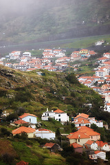 Image showing Houses, hill with village or countryside landscape, travel and adventure location with nature and buildings. Neighborhood, real estate and property with architecture for holiday in Portugal