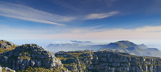 Image showing Mountain, clouds and blue sky with horizon, natural landscape and calm cliff at travel location. Nature, fog and sustainable environment with earth, peace and holiday destination at tropical island