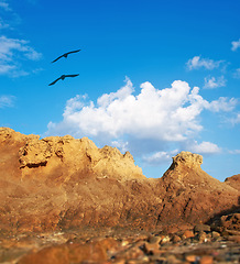 Image showing Mountain, birds and natural landscape with blue sky, sun and calm clouds on peak at travel location. Nature, cliff and environment with earth, flight and holiday destination in wilderness with rocks