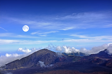 Image showing Mountain, clouds and natural landscape with blue sky, horizon and summit for travel destination. Nature, sustainable environment and volcano for adventure, explore or summer vacation in Hawaii.