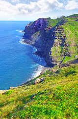 Image showing Mountain, island and ocean with green landscape, summer and calm water on peak at travel location. Nature, cliff and sustainable environment with earth, drone and sky on tropical holiday destination